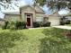 Charming single-story home with a well-manicured lawn and a vibrant red front door at 3539 Maple Ridge Loop, Kissimmee, FL 34741