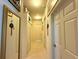 Long hallway with tile floor and multiple doorways, providing access to different areas of the home at 3539 Maple Ridge Loop, Kissimmee, FL 34741