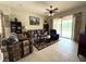Comfortable living room featuring tile floors, ceiling fan, and sliding glass doors at 3539 Maple Ridge Loop, Kissimmee, FL 34741