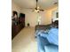 A large main bedroom featuring a ceiling fan, ensuite bathroom, and classic decor with a blue armchair at 3539 Maple Ridge Loop, Kissimmee, FL 34741