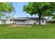 Spacious backyard with lush green grass and a covered patio area, perfect for outdoor entertaining at 4 Kasey Dr, Orlando, FL 32807