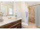 Bright bathroom with a stone shower, a dark wood vanity, and a decorative shower curtain at 4 Kasey Dr, Orlando, FL 32807