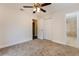 Comfortable bedroom with neutral carpet, ceiling fan, closet, and an open doorway to the bathroom at 4 Kasey Dr, Orlando, FL 32807