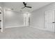 Bedroom featuring light walls, carpet, ceiling fan, and doors to ensuite bathroom at 42157 Tamarac St, Eustis, FL 32736