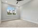 Bedroom showcasing a large window, neutral gray paint, and carpet flooring at 42157 Tamarac St, Eustis, FL 32736