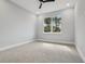 Bedroom showcasing a large window, neutral gray paint, and carpet flooring at 42157 Tamarac St, Eustis, FL 32736