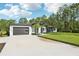 Contemporary home with a spacious driveway and manicured lawn, set against a backdrop of lush trees at 42157 Tamarac St, Eustis, FL 32736