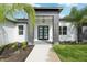 Close-up of a modern home's entrance, featuring double glass doors and manicured landscaping at 42157 Tamarac St, Eustis, FL 32736