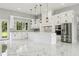 Spacious kitchen with white cabinets, a large island, marble floors, and modern, stainless steel appliances at 42157 Tamarac St, Eustis, FL 32736