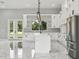 Kitchen with white cabinets, marble floors, stainless steel appliances, and a view to the backyard at 42157 Tamarac St, Eustis, FL 32736