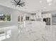 Open-concept living room and kitchen area featuring sleek marble floors and modern white cabinetry at 42157 Tamarac St, Eustis, FL 32736