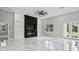 Spacious living room featuring a sleek black fireplace, marble floors, and a view to the outdoors through a window at 42157 Tamarac St, Eustis, FL 32736