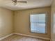This bedroom features neutral paint, tile floor, ceiling fan, and a window with blinds allowing natural light in at 436 Hunter Cir, Kissimmee, FL 34758