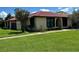 Single-story home with lawn, simple landscaping, red tile roof, and light yellow exterior at 436 Hunter Cir, Kissimmee, FL 34758