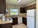 Kitchen features wood cabinets, white appliances, neutral countertops, and tile floor at 436 Hunter Cir, Kissimmee, FL 34758