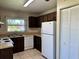 Kitchen with wood cabinets, neutral countertops, white appliances, and tile flooring at 436 Hunter Cir, Kissimmee, FL 34758