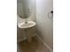 Powder room featuring a pedestal sink, modern faucet, oval mirror, and neutral color palette at 454 Wilton Cir, Sanford, FL 32773