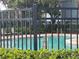 A swims in a community pool enclosed by a black iron fence and lush greenery at 454 Wilton Cir, Sanford, FL 32773