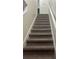 Carpeted staircase with white handrail providing access to upper levels of the home at 454 Wilton Cir, Sanford, FL 32773