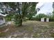 Spacious backyard featuring mature trees and a storage shed, offering plenty of outdoor space at 535 Romano Ave, Orlando, FL 32807