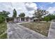 Street view of a single-story home with a long driveway and covered carport, set on a sunny day at 535 Romano Ave, Orlando, FL 32807