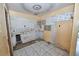 Outdated kitchen with damaged walls, missing cabinets and dated tile floors in need of complete renovation at 535 Romano Ave, Orlando, FL 32807