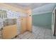 Outdated kitchen with damaged walls, missing cabinets and dated tile floors in need of complete renovation at 535 Romano Ave, Orlando, FL 32807