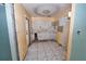 Outdated kitchen with damaged walls, missing cabinets and dated tile floors in need of complete renovation at 535 Romano Ave, Orlando, FL 32807