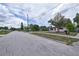 Residential street featuring a single-story home with mature trees, a xeriscaped yard, and a carport at 535 Romano Ave, Orlando, FL 32807