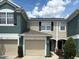 Charming townhome featuring a one-car garage and inviting facade with lush landscaping at 650 Shropshire Loop, Sanford, FL 32771