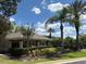 View of the poolside, showing a pool building with picnic area surrounded by tropical landscaping under a sunny blue sky at 650 Shropshire Loop, Sanford, FL 32771
