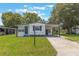 Inviting single-story home with a carport, green lawn, and mature trees offering curb appeal at 814 Roseapple Ave, Lady Lake, FL 32159