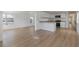 Open-concept kitchen with white cabinets, new appliances, and wood-look laminate flooring at 814 Roseapple Ave, Lady Lake, FL 32159