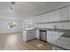 Modern kitchen featuring white cabinets, updated appliances, and granite countertops at 814 Roseapple Ave, Lady Lake, FL 32159