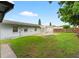 Well-maintained backyard with lush green grass, small patio and partial privacy fence at 830 Hawkes Ave, Orlando, FL 32809