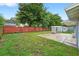 Expansive backyard featuring a well-maintained lawn, privacy fence, and a charming white lattice pergola at 830 Hawkes Ave, Orlando, FL 32809