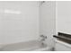 Bathroom featuring a clean bathtub with white tile surround, complete with fixtures and design at 830 Hawkes Ave, Orlando, FL 32809