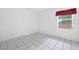 Bedroom featuring tile flooring and a window with red curtains at 830 Hawkes Ave, Orlando, FL 32809