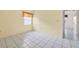 This bedroom has tile flooring, light-colored walls, and a bright window with blinds at 830 Hawkes Ave, Orlando, FL 32809