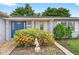 Close-up of a blue front door with vibrant landscaping and decorative shutters at 830 Hawkes Ave, Orlando, FL 32809