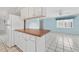 Bright kitchen features white cabinets and wood countertops opening to living area with tile floors at 830 Hawkes Ave, Orlando, FL 32809