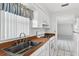 Bright kitchen features white cabinets, matching appliances, and wood countertops with a stainless sink at 830 Hawkes Ave, Orlando, FL 32809