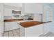 Bright kitchen features white cabinets, matching appliances, and wood countertops with a breakfast bar at 830 Hawkes Ave, Orlando, FL 32809