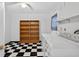 Bright laundry room features tile floors, washer and dryer, shelving, and window at 830 Hawkes Ave, Orlando, FL 32809