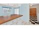 Bright laundry room with wood countertop, white cabinets, and tile floors leading to laundry room at 830 Hawkes Ave, Orlando, FL 32809