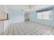 Cozy living space with tiled flooring, natural lighting, and a partial view of the kitchen at 830 Hawkes Ave, Orlando, FL 32809