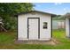 Exterior shot of the backyard storage shed with a white exterior and black trim at 830 Hawkes Ave, Orlando, FL 32809