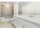 Bathroom with a dual sink vanity and a shower-tub combination featuring gray tiling at 9027 Coral Cape St, Kissimmee, FL 34747