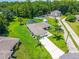 Aerial view of property highlighting lush backyard with screened pool, mature landscaping, and long driveway leading to a lovely home at 909 Hendon Place, Kissimmee, FL 34758