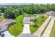 Aerial view of a home with green lawn, mature trees, and a screened pool at 909 Hendon Place, Kissimmee, FL 34758